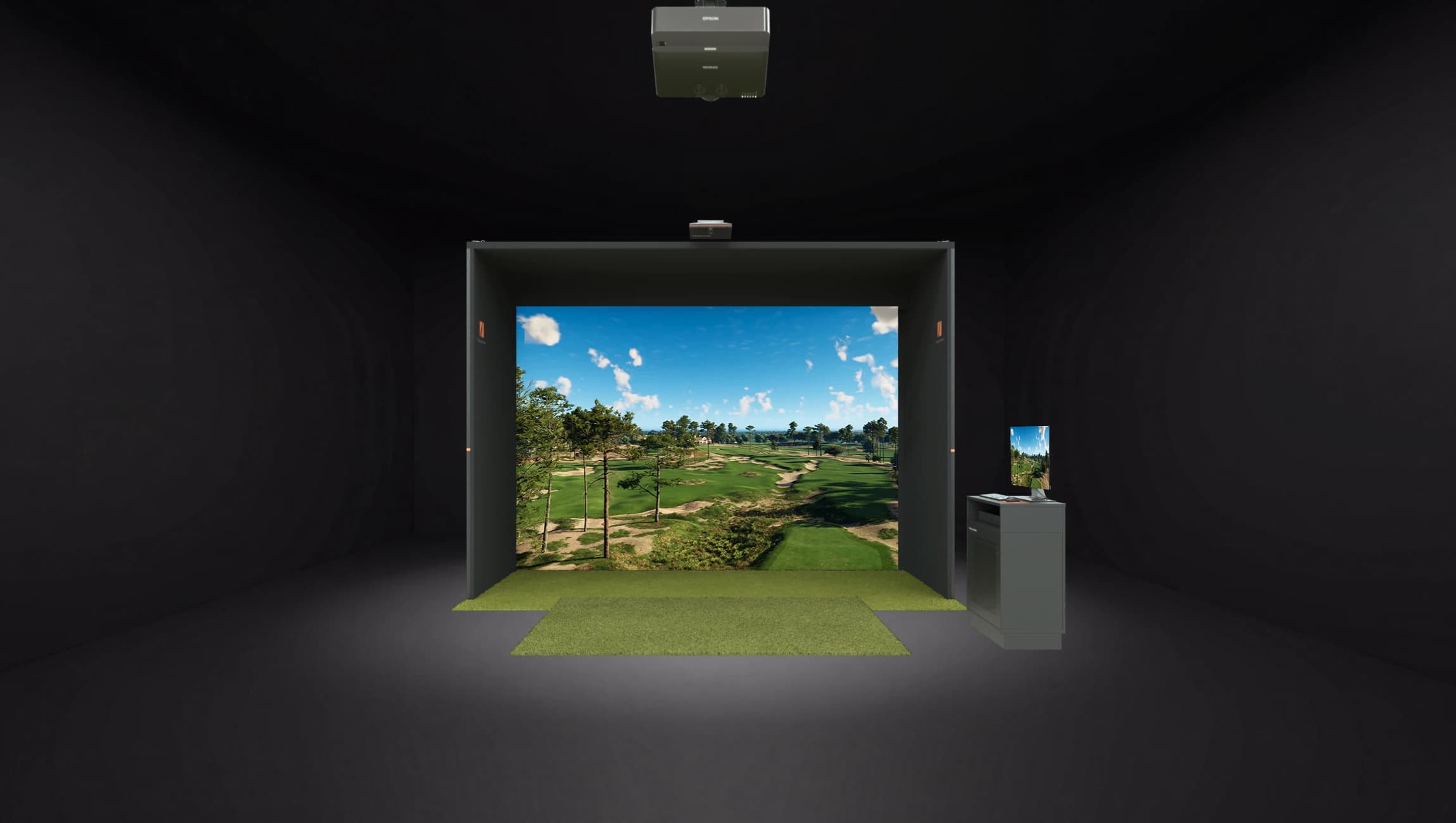 Indoor golf simulator room with a realistic green field projection and a computer station on the right.