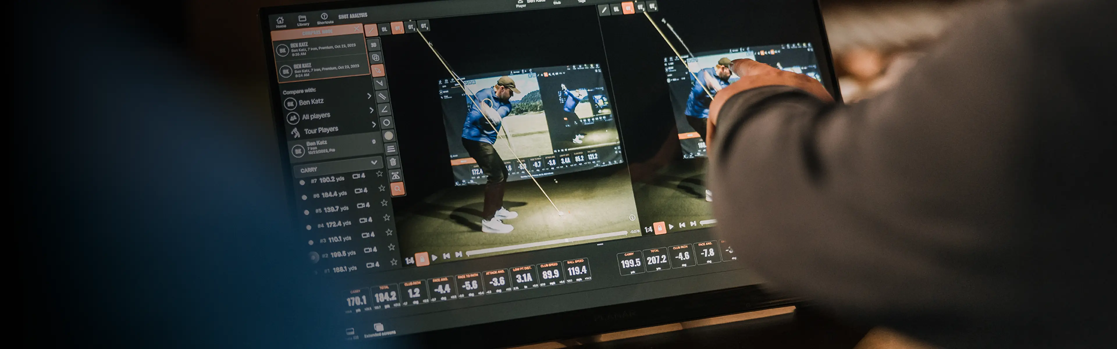 A person points at a digital screen displaying detailed golf swing analysis and performance metrics.